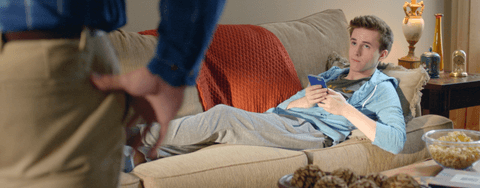 Young person on the couch with a cell phone.