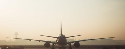 Airplane on a runway from behind.